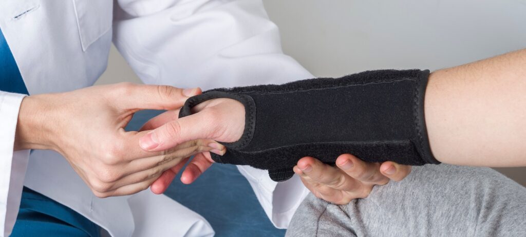 Doctor fitting a wrist brace.