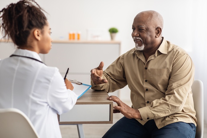 Doctor listening to a patient describe his pain symptoms