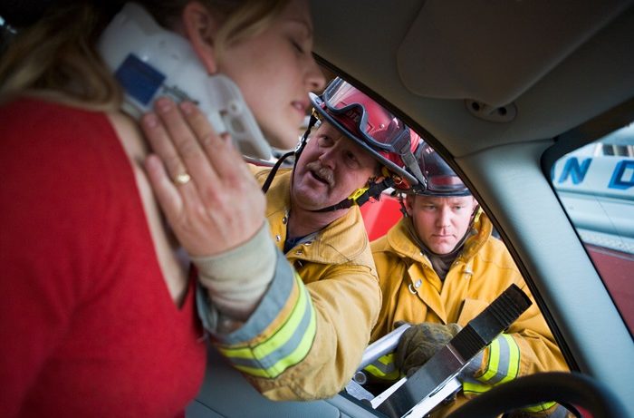EMT fitting neck brace to car accident victim.