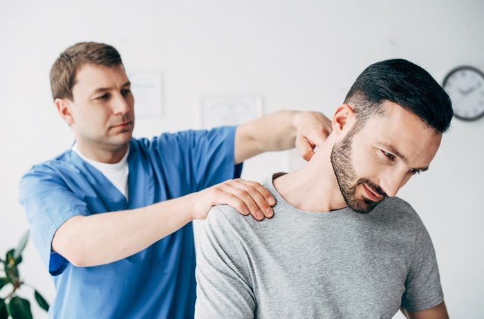Doctor treating a neck injury patient